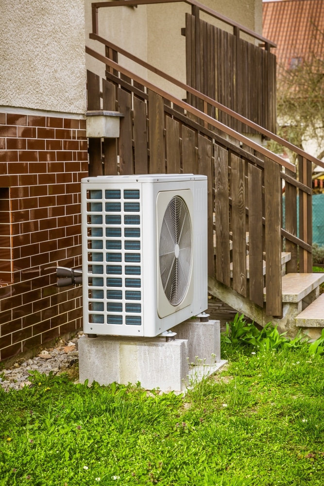 Baignoire îlot moderne : design minimaliste et ambiance spa. Baignoire îlot blanche, robinetterie minimaliste et parquet en bois clair à chevrons. Étagères intégrées décoratives dans la salle de bain moderne.
