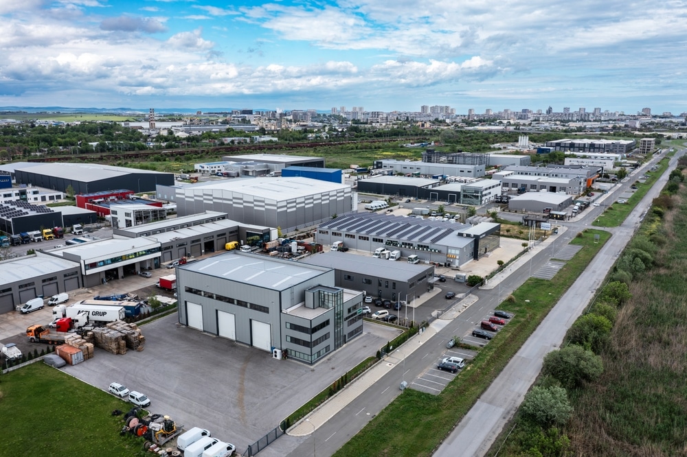 Baignoire îlot moderne : design minimaliste et ambiance spa. Baignoire îlot blanche, robinetterie minimaliste et parquet en bois clair à chevrons. Étagères intégrées décoratives dans la salle de bain moderne.
